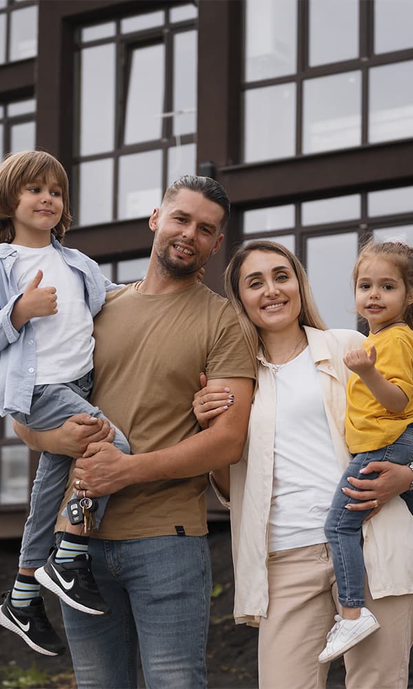 Família sorrindo em frente de casa